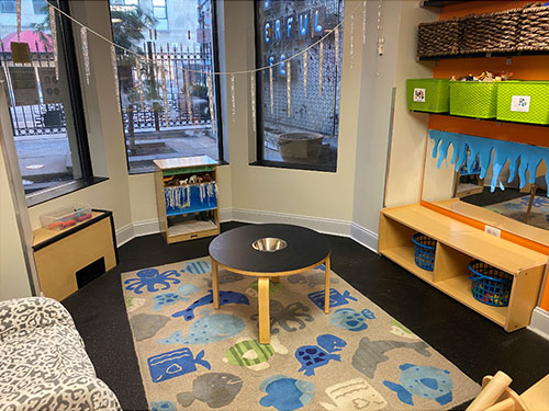 Photo of Urban Child Academy's Gold Coast Tddler's Room with play table and bins