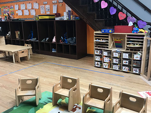 Photo of Urban Child Academy's Gold Coast Two's Room with child's chairs and cubbies